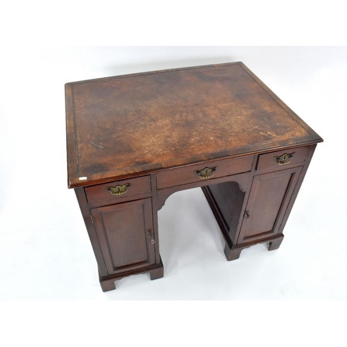 95 - A George III mahogany kneehole writing desk, the rectangular top with brown leather surface, over th... 