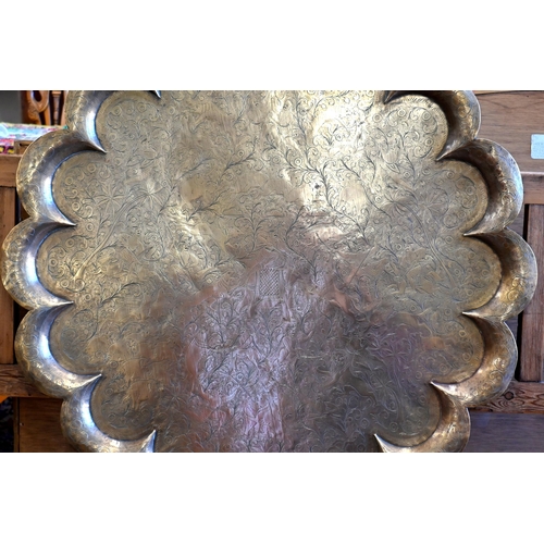 206 - A large Indian brass lobed tray, richly engraved with tiger and boar hunts, 82 cm