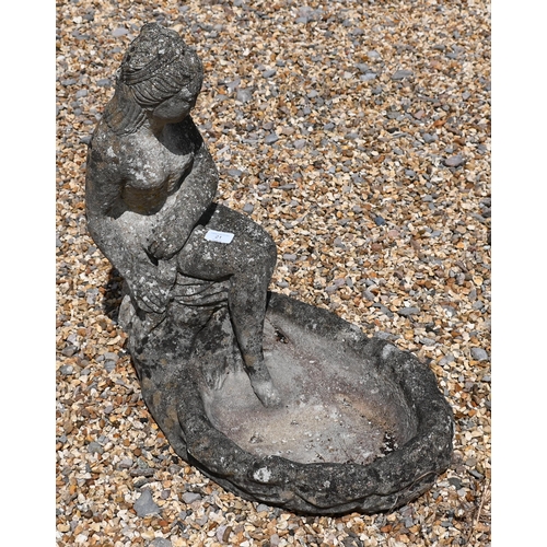 21 - A reconstituted weathered stone bird bath cast with seated female, 56 cm high