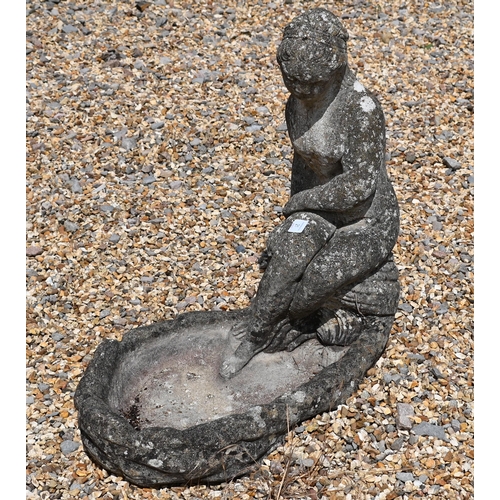 21 - A reconstituted weathered stone bird bath cast with seated female, 56 cm high
