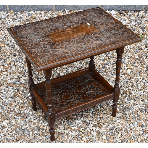 33 - A rectangular oak two-tier side table with floral and foliate carved decoration on slender turned su... 