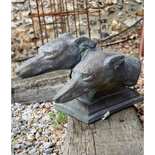 11 - A reconstituted stone garden ornament of two greyhound heads on plinth base, aged bronzed finish, 30... 