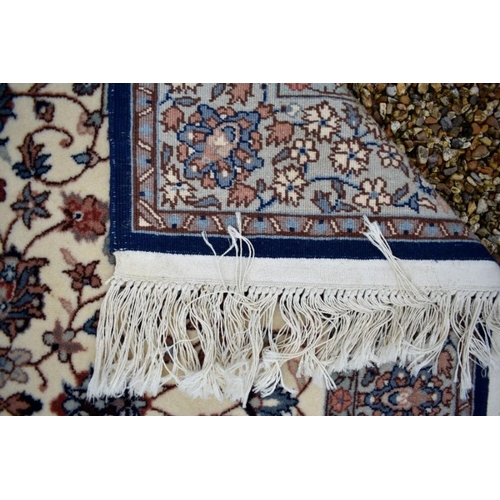 506 - A classic Nian rug, the traditional cream ground with floral design centred by a blue medallion, 154... 