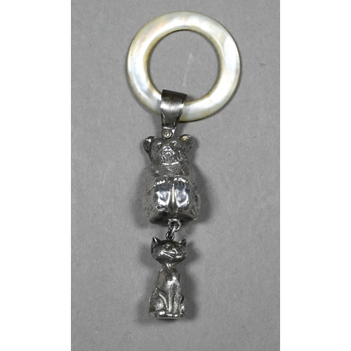 101 - An Edwardian silver baby's rattle with mother of pearl teething ring, hung with teddy bear and grinn... 