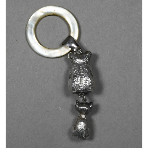 101 - An Edwardian silver baby's rattle with mother of pearl teething ring, hung with teddy bear and grinn... 