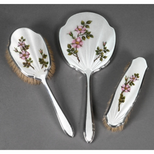 13 - Silver and enamel three piece brush set with hand mirror, decorated with roses, Walker & Hall, S... 