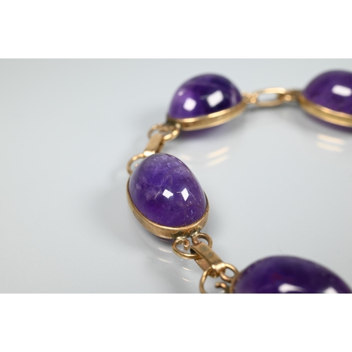 150 - An amethyst bracelet, the six oval cabochon stones with scroll links between, snap clasp, 18 cm long... 