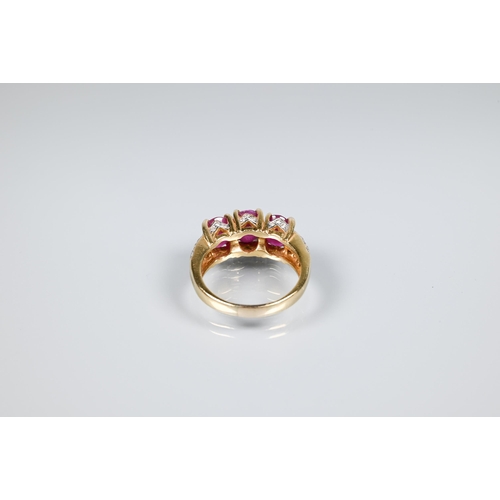 152 - A ruby ring, the three oval rubies claw set, with diamond set gallery and split shoulders, yellow me... 