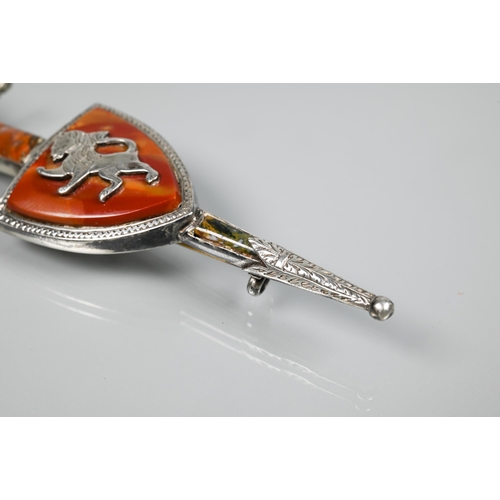 168 - A Scottish kilt pin in the form of a sheathed sword and shield inset with agate, white metal set wit... 