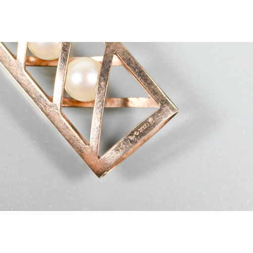 173 - A 9ct yellow gold cagework pendant enclosing three cultured pearls within, 3.5 cm long