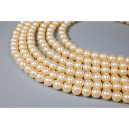 184 - Gay Bowyer - a six-strand faux pearl choker with oval blue cabochon clasp and matching earrings stam... 