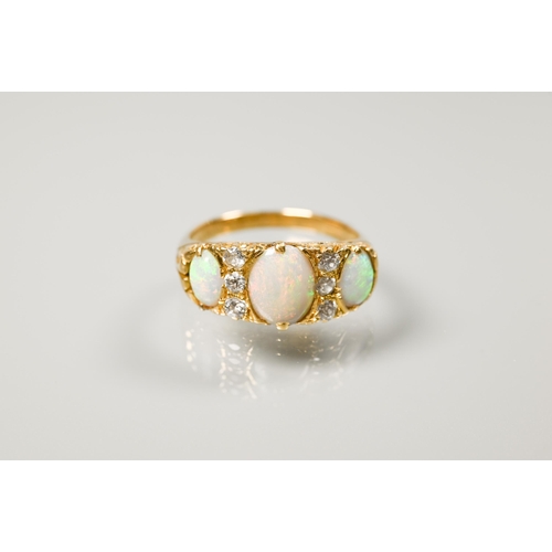 186 - An antique three-stone opal and diamond ring, the graduated opals with three small diamonds between,... 