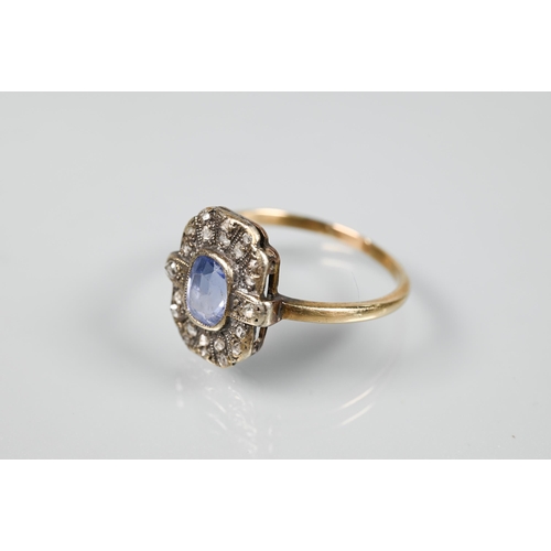 192 - An antique plaque ring, the central pale blue oval sapphire surrounded by rose cut diamonds in milgr... 