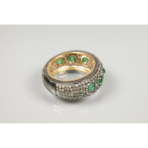 201 - A South African diamond and emerald bombe eternity ring, the pavé set diamonds set with seven gradua... 