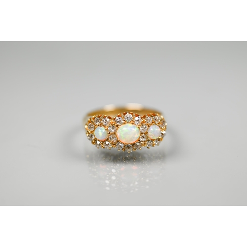 208 - A Victorian opal and diamond cluster ring, the graduated circular opals surrounded by old cut diamon... 