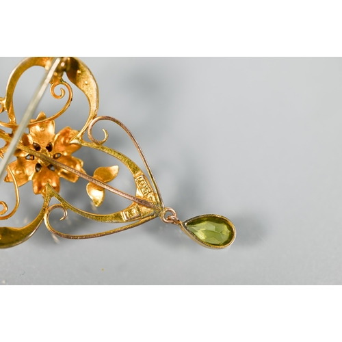 217 - An Art Nouveau flower and scroll open pendant, set overall with seed pearls and with central ruby, w... 