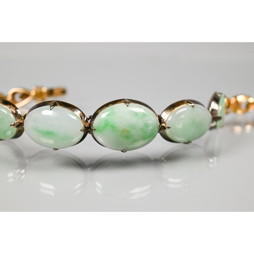 220 - A jade-set bracelet, the five mottled jade cabochons with closed-back settings, and four shaped link... 