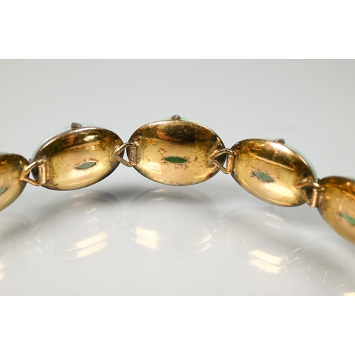 220 - A jade-set bracelet, the five mottled jade cabochons with closed-back settings, and four shaped link... 