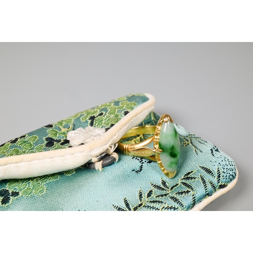 222 - A marquis-shaped green jade set ring, unmarked yellow metal, with engraved shoulders, size M