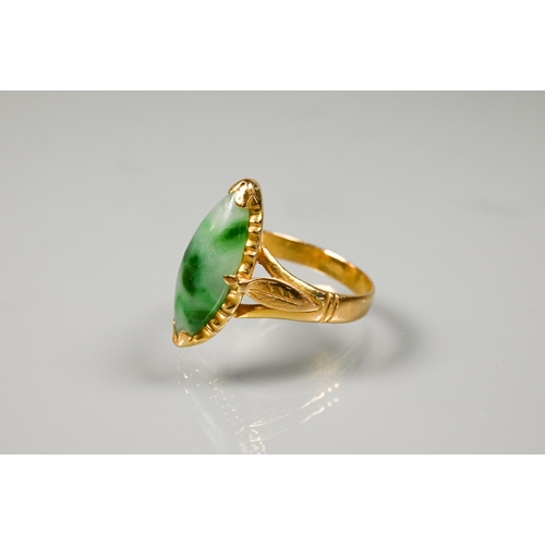 222 - A marquis-shaped green jade set ring, unmarked yellow metal, with engraved shoulders, size M