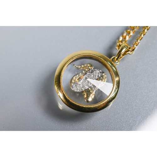 223 - A Chopard-style 'Happy' snake pendant with rotating diamond-set serpent within, yellow metal stamped... 