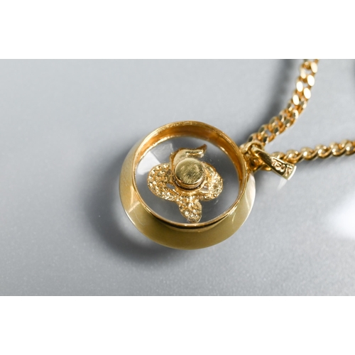 223 - A Chopard-style 'Happy' snake pendant with rotating diamond-set serpent within, yellow metal stamped... 