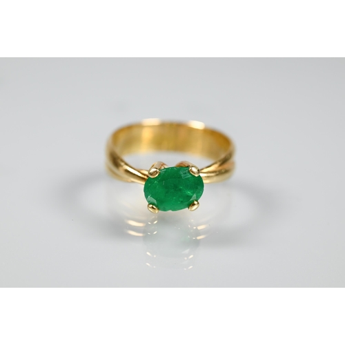 227 - An oval included green emerald ring in high prong setting, and conjoined shank, yellow metal stamped... 