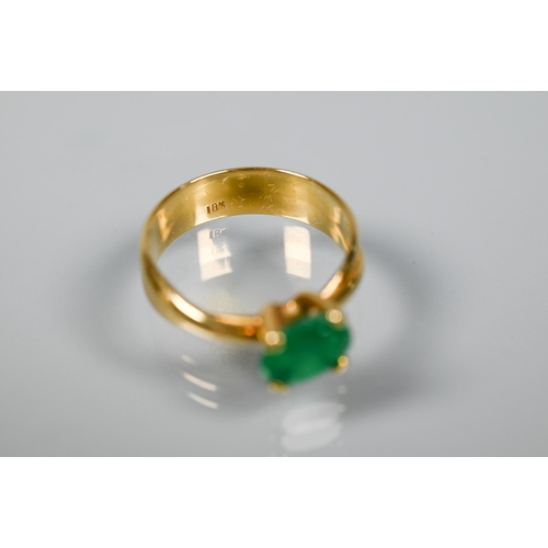 227 - An oval included green emerald ring in high prong setting, and conjoined shank, yellow metal stamped... 