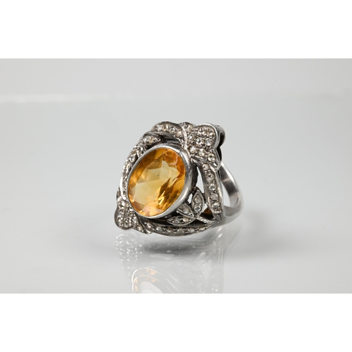 232 - A statement diamond and citrine cluster ring, the oval citrine with pavé set diamonds in Gothic-styl... 