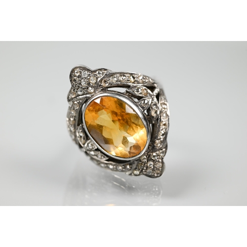 232 - A statement diamond and citrine cluster ring, the oval citrine with pavé set diamonds in Gothic-styl... 