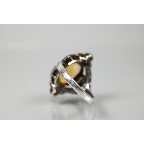 232 - A statement diamond and citrine cluster ring, the oval citrine with pavé set diamonds in Gothic-styl... 