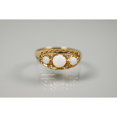 233 - A 9ct gypsy-style ring set with three graduated circular opals with two small diamonds between, size... 