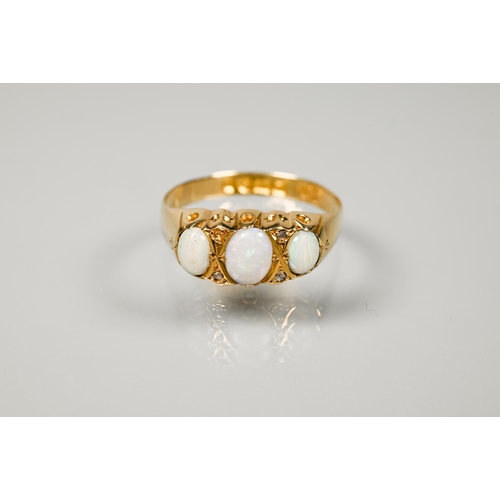 235 - An antique 18ct yellow gold ring set with three graduated oval opals and two diamonds between (one m... 