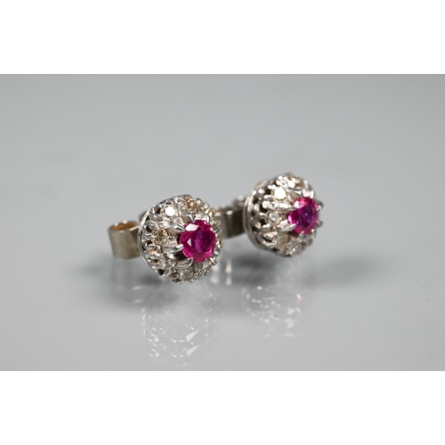 244 - A pair of white stone and ruby cluster earrings, the central circular ruby surrounded by eight white... 