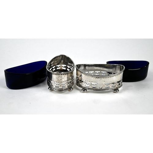 25 - A pair of late Victorian elliptical silver open salts with pierced sides and blue glass liners, on b... 
