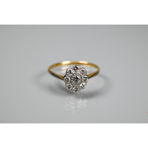 269 - An antique diamond cluster daisy ring, the central oval set circular stone with eight circular diamo... 