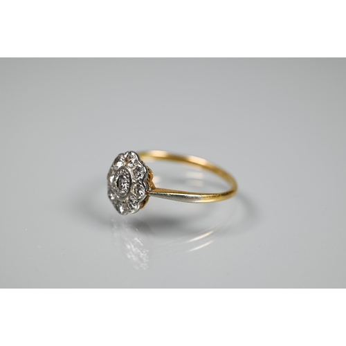 269 - An antique diamond cluster daisy ring, the central oval set circular stone with eight circular diamo... 