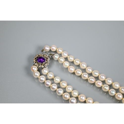 271 - A double row of circular cultured pearls, double knotted throughout onto white metal and diamond set... 