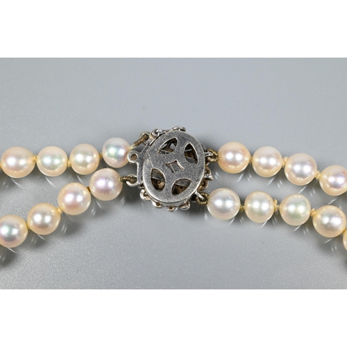 271 - A double row of circular cultured pearls, double knotted throughout onto white metal and diamond set... 