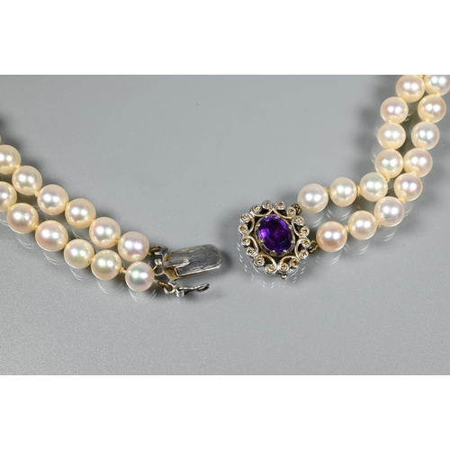 271 - A double row of circular cultured pearls, double knotted throughout onto white metal and diamond set... 