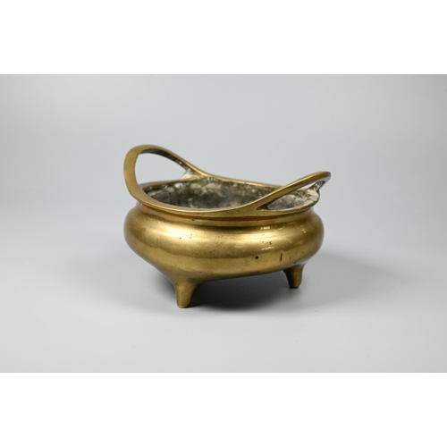 292 - A 19th century Chinese polished bronze censer with a pair of loop handles on a compressed globular b... 