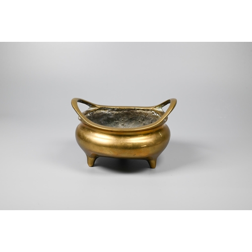 292 - A 19th century Chinese polished bronze censer with a pair of loop handles on a compressed globular b... 