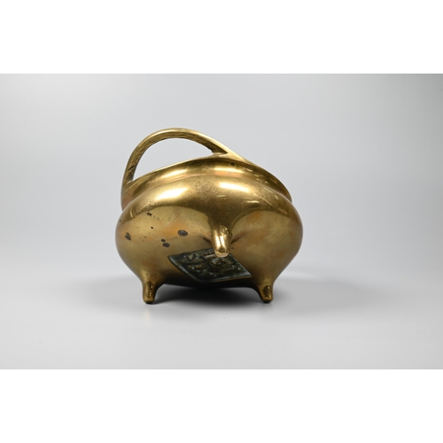 292 - A 19th century Chinese polished bronze censer with a pair of loop handles on a compressed globular b... 