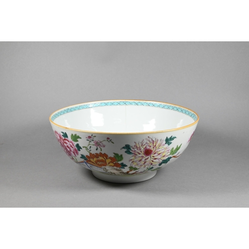 298 - An 18th century Chinese famille rose punch bowl painted with large blossoming peonies in a fenced ga... 