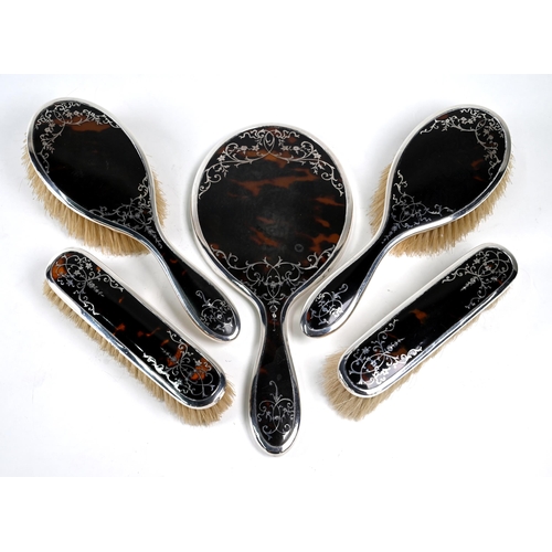30 - A silver and tortoiseshell piqué five-piece brush set including hand mirror, Mappin & Webb, Birmingh... 