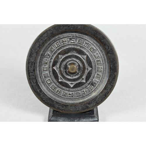 314 - A 19th century Chinese bronze circular mirror in the Tang style, one side cast in relief with callig... 