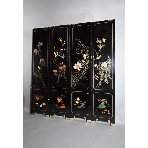 327A - An early 20th century Chinese lacquered four panel screen painted and gilded with idyllic landscapes... 