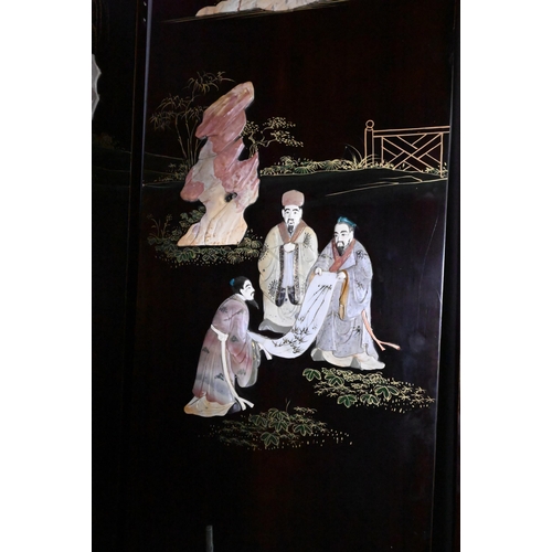 327A - An early 20th century Chinese lacquered four panel screen painted and gilded with idyllic landscapes... 