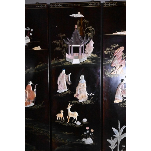 327A - An early 20th century Chinese lacquered four panel screen painted and gilded with idyllic landscapes... 