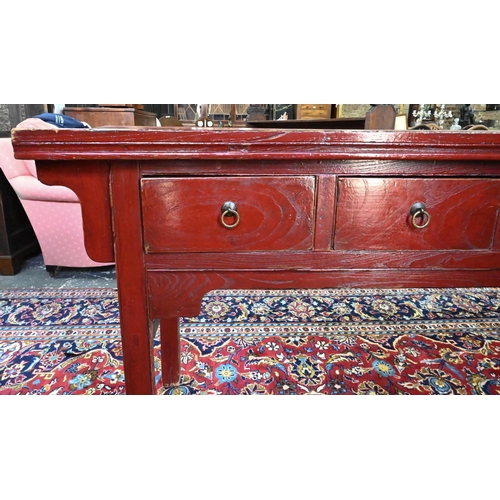 330 - An antique Chinese red lacquer four drawer side table / altar table, raised on square section legs, ... 